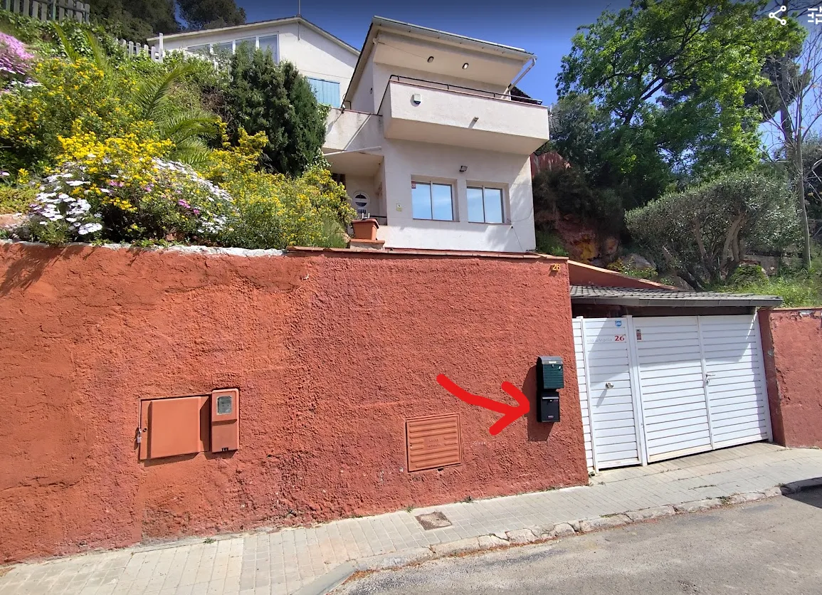 Buzón negro en la pared roja de la oficina de Pallejà donde se recogen las cartas náuticas del PER